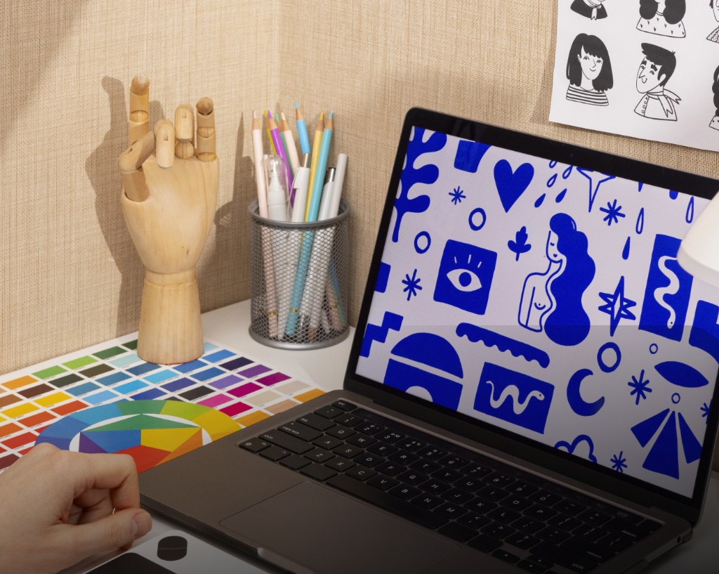 Workspace de diseño con laptop, paleta de colores y herramientas creativas