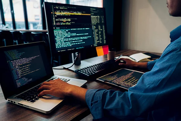 Desarrollador trabajando con código en múltiples pantallas